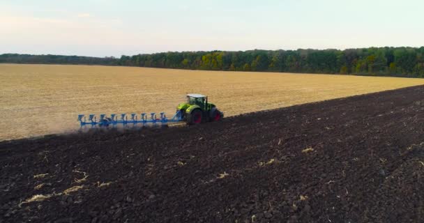 Tracteur fonctionne dans la vue de dessus de champ. Survoler le tracteur sur le terrain. Le tracteur laboure le champ. — Video