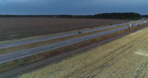 El camión conduce por la carretera, campos en el fondo. El camión conduce a lo largo de la carretera en medio de campos agrícolas vista superior. — Vídeo de stock