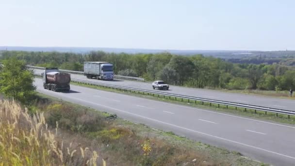 Грузовик едет по плоской современной дороге за городом. Грузовик едет по дороге в солнечный день — стоковое видео