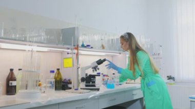 Laboratuvarda güzel bir kız deneyler yapıyor. Kimya laboratuvarında genç bir laboratuvar asistanı.