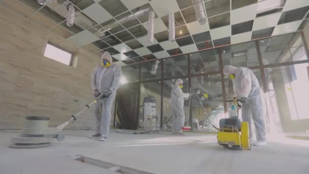 Les constructeurs polissent le sol avec un équipement spécial. Rectification de surface du béton. Constructeurs sur un chantier — Video