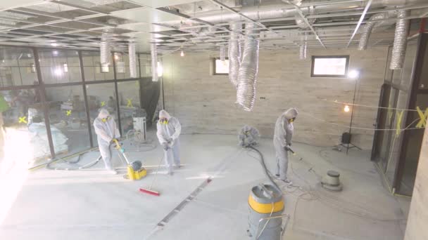 Moagem de superfície de concreto. Construtores num estaleiro. Os construtores estão a polir o chão com equipamento especial. — Vídeo de Stock