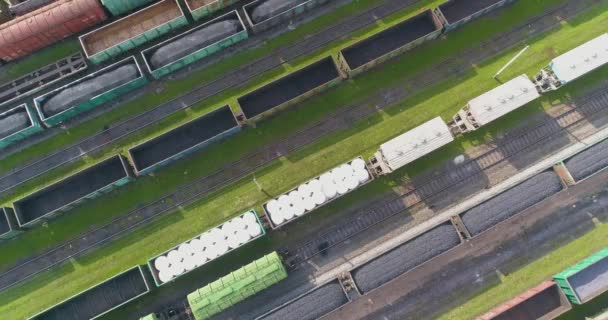 Un treno merci si muove attraverso un telaio della stazione ferroviaria con rotazione dall'alto. Grande struttura della stazione ferroviaria con rotazione — Video Stock