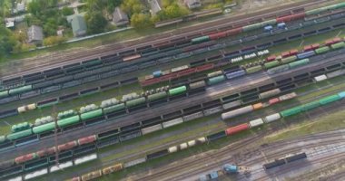 Büyük demiryolu kavşağı hava manzaralı. Tren istasyonunda bir sürü tren var. Çok sayıda demiryolu hattı ve yük treni olan bir depo.
