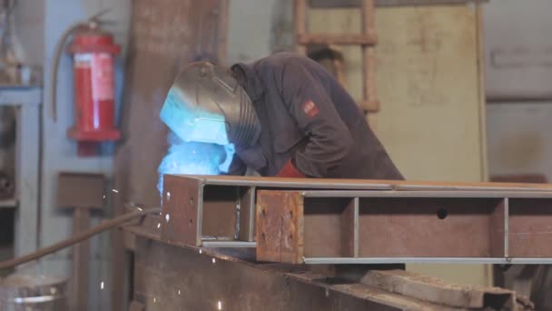 . Svářečka pracuje v továrně. Svářeč sbírá kovové dílčí svařování — Stock video