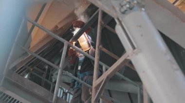 Bir kaynakçı metal parçaları kaynak yapar. Fabrikada kaynakçı. İnşaat işçisi