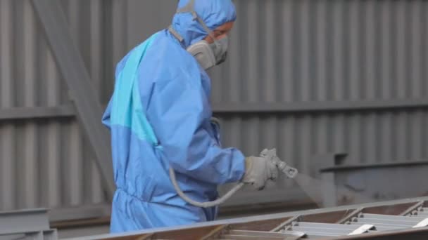 Fabrikada metal parçalarının boyanması. Koruyucu giysili işçiler detayları boyar. — Stok video