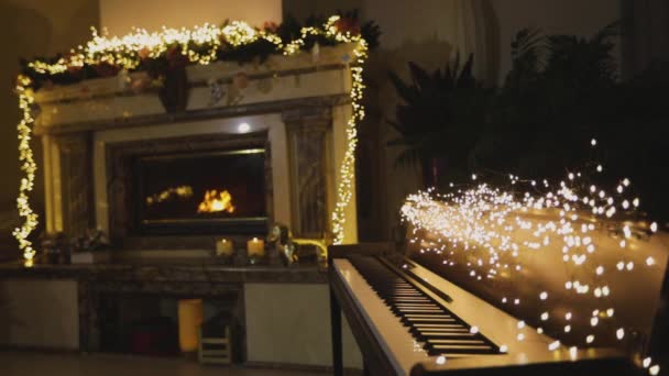 Een synthesizer tegen de achtergrond van een open haard in het kerstinterieur — Stockvideo