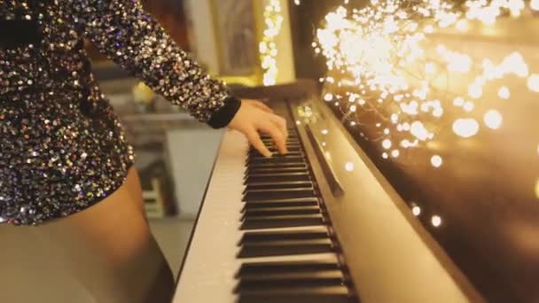 Händerna spelar synthesizer. En kvinna spelar synthesizer i nyårsinredningen. Spelar synthesizer — Stockvideo