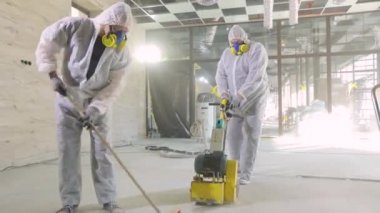 Beton yüzey öğütme. İnşaatçılar zemini özel ekipmanlarla cilalıyorlar. İnşaat alanında inşaatçılar