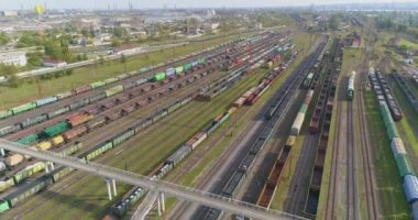 Güneşli havada demiryolu kavşağı, üst manzara. Tren istasyonunun üst manzarasındaki yük trenleri. Demiryolu kavşağındaki yük trenleri