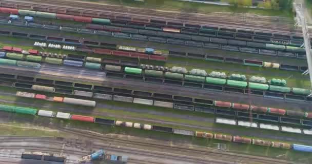 Grande vista aérea da junção ferroviária. Há muitos trens no depósito ferroviário. Depósito com um grande número de linhas ferroviárias e trens de carga — Vídeo de Stock