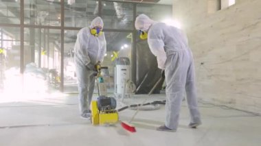 Beton yüzey öğütme. İnşaat alanındaki inşaatçılar. İnşaatçılar zemini özel ekipmanlarla parlatıyorlar..