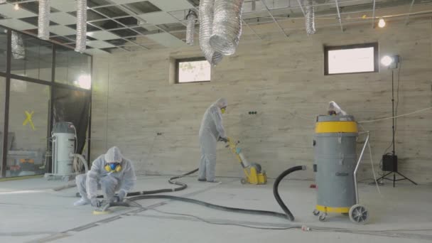 建筑工人们正在用特殊的设备把地板磨光.混凝土表面研磨。建筑工地的建筑商 — 图库视频影像