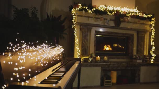 Een synthesizer tegen de achtergrond van een open haard in het kerstinterieur — Stockvideo