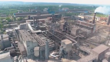 Büyük bir bitkiden duman. Büyük bir metalürjik tesisin üzerinden uçmak. Büyük fabrika manzaralı. Bitkinin bacasından tehlikeli emisyonlar geliyor..