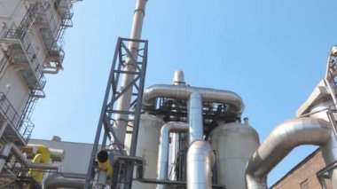 Fabrikada bir sürü büyük parlak borular var. Büyük metal parlak borular.