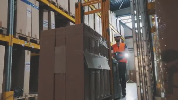 Moderne speciale apparatuur op voorraad. Een arbeider vervoert een lading op een elektrische hydraulische heftruck. Groot modern magazijn. — Stockvideo