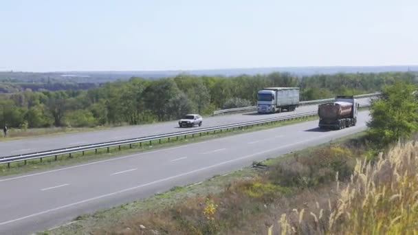 卡车在高速公路上行驶.卡车在公路上绕着田野和树木行驶 — 图库视频影像