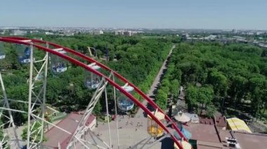 Dönme dolap, insanlar dönme dolabın yanındaki meydanda yürüyor, hava manzaralı.