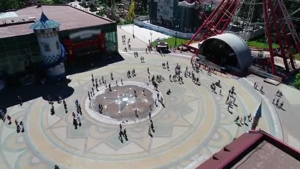 As pessoas caminham na praça perto da roda gigante, vista aérea — Vídeo de Stock