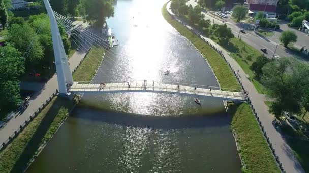 Sétáló híd a folyó felett, fehér gyönyörű gyalogos híd a folyó túloldalán — Stock videók