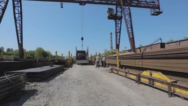 Werknemers laden metaal in een vrachtwagen, mensen werken in een magazijn, laden vracht in een vrachtwagen. Vrachtwagen onder de portaalkraan — Stockvideo