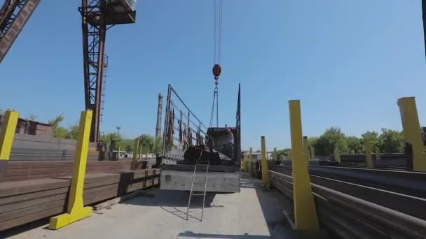 Workers load metal into a truck, people work in a warehouse, load cargo into a truck. Truck under the gantry crane — Stock Video