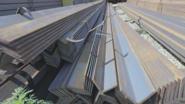 Depodaki metal köşeler üst üste dizilmiş, metal açık hava deposunda yuvarlanıyor.