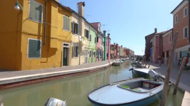 Burano adası, insanlar Burano adasının kanalı boyunca yürüyorlar. Venedik, İtalya.