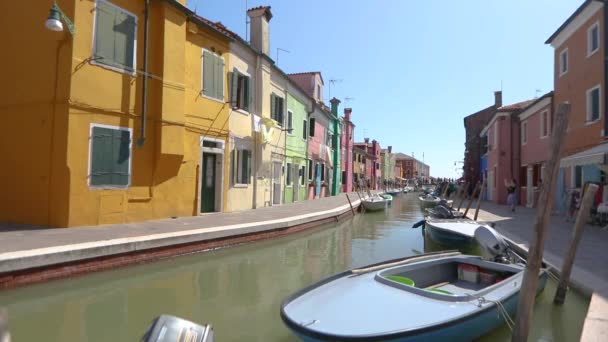 Île de Burano, les gens marchent le long des rues du canal de l'île de Burano. Venise, Italie. — Video