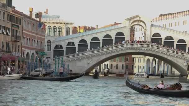 Мост Риальто через Гранд-канал, лодка под мостом Риальто Венеция, Италия. Венецианский канал, много лодок в Большом канале — стоковое видео