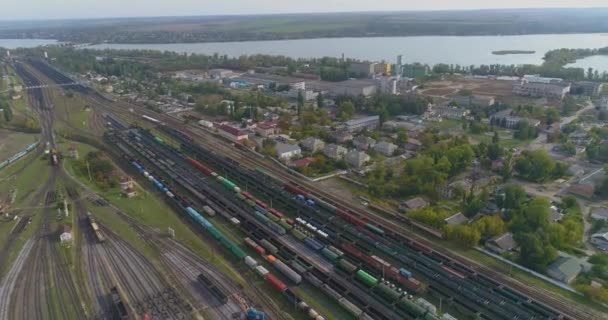 Grande jonction ferroviaire vue aérienne. Il y a beaucoup de trains au dépôt ferroviaire. Dépôt avec un grand nombre de lignes ferroviaires et de trains de marchandises — Video