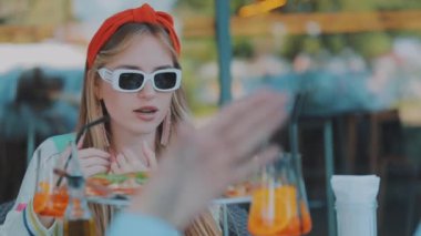 Yakın plan pizza, pizza ve kokteyl restoranda bir masanın üzerinde. Arka planda genç bir kız.