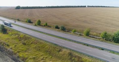 Kamyon uzun, düz bir yol boyunca gider. Kamyon yol boyunca gidiyor, doğa etrafta. Vagon, İHA ateşi altında yol boyunca gidiyor.