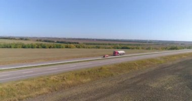 Kamyon uzun, düz bir yol boyunca gider. Kamyon yol boyunca gidiyor, doğa etrafta. Vagon, İHA ateşi altında yol boyunca gidiyor.