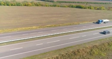 Kamyon yolda gidiyor, tarlalar arka planda. Malların kamyonla taşınması. Kamyon, tarımsal alanların ortasında yol boyunca gidiyor..