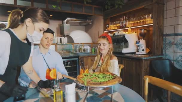 Der Typ mit dem Mädchen in der Pizzeria. Mädchen mit einem Mann bei einem Date in einer Pizzeria — Stockvideo