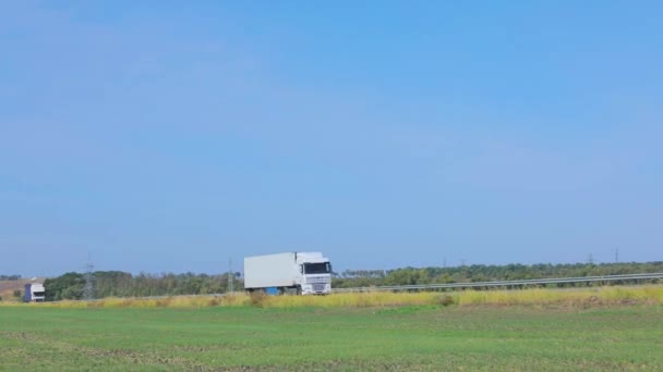 Vagnen kör längs en vacker väg på sommaren. En vagn rider en väg mot en blå himmel — Stockvideo