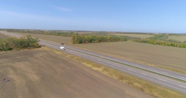 Vrachtwagen rijdt langs de velden bij zonnig weer. Vrachtwagen rijdt op een prachtige weg. De truck rijdt langs de velden bovenaanzicht. — Stockvideo