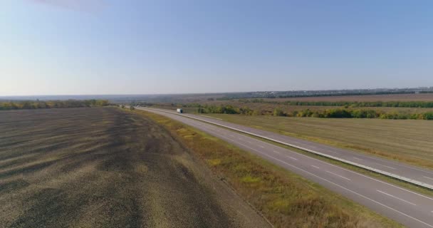 El camión conduce por la carretera, campos en el fondo. El camión conduce a lo largo de la carretera en medio de campos agrícolas vista superior. — Vídeo de stock