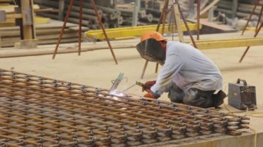 Bir kaynakçı metal bir yapıyı kaynak yapar. Kaynak metal yapımı. Güçlendirilmiş beton takviyesi