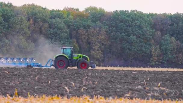 Трактор вспахивает сельскохозяйственное поле. Обработка поля трактором. Трактор обрабатывает поле. — стоковое видео