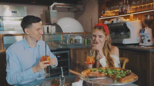 Der Typ mit dem Mädchen in der Pizzeria. Mädchen mit einem Mann bei einem Date in einer Pizzeria — Stockvideo