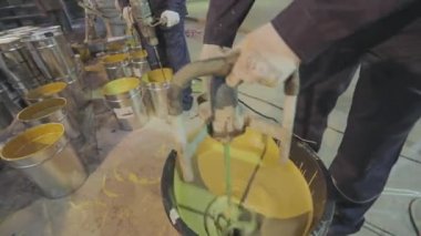Bir işçi kovada kendi seviyesini yükselten zemini karıştırıyor. Adam başvurmadan önce kendi seviyesini yükselten zemini karıştırıyor. İnşaat alanında çalışma süreci