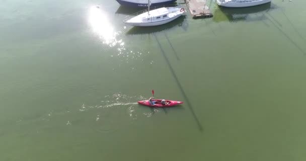 Una coppia è in canoa sul lago. La gente nuota sul lago su una canoa vista dall'alto. Vola sopra la canoa nel lago — Video Stock