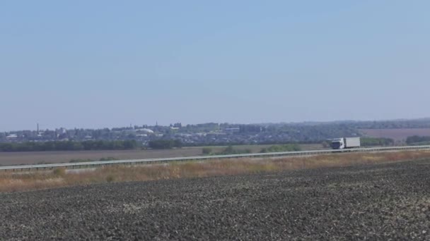 卡车在高速公路上行驶.卡车在公路上绕着田野和树木行驶 — 图库视频影像