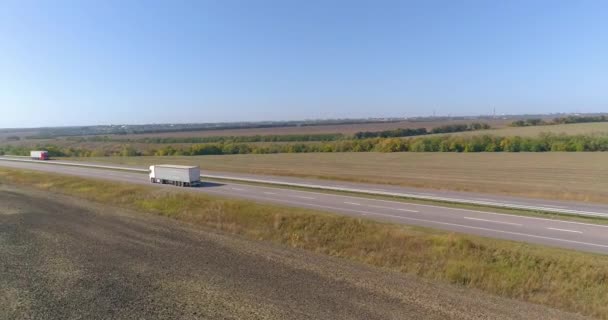 Un chariot blanc roule le long de l'autoroute par beau temps. Le camion longe l'autoroute par temps ensoleillé. Le chariot roule sur une belle route — Video