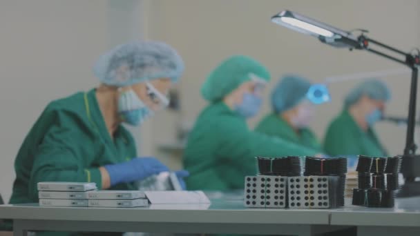 Fabrieksarbeiders nemen pillen. Gemaskerde arbeiders. Workflow in een farmaceutische fabriek — Stockvideo