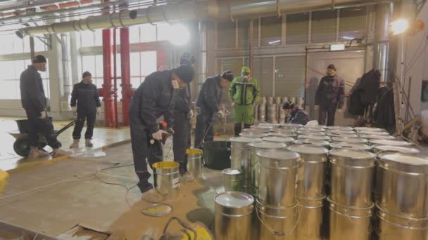 Construtores em um canteiro de obras, recipientes de metal em primeiro plano. Processo de trabalho num estaleiro. — Vídeo de Stock